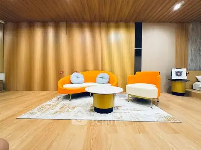 Modern living room with vibrant orange furniture and wooden accents.