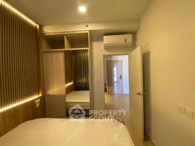 Modern bedroom with built-in wardrobe and air conditioning in a stylish apartment.