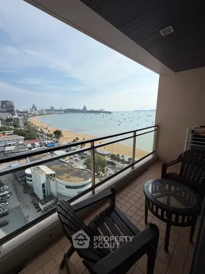 Stunning beachfront balcony with panoramic ocean views and stylish outdoor seating, perfect for relaxation.