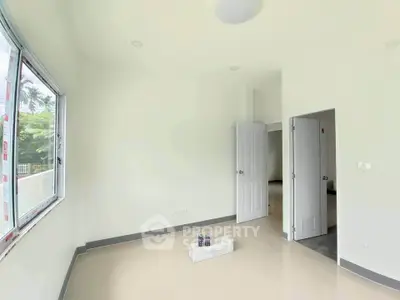 Bright empty room with large window and open doors in modern home