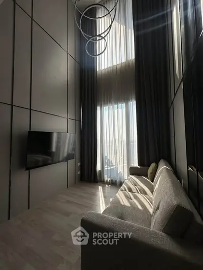 Luxurious high-ceiling living room with modern decor and large windows