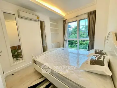 Bright bedroom with large window and modern decor, featuring a comfortable bed and air conditioning.