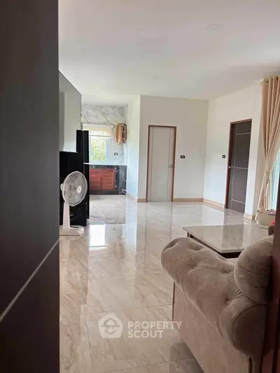 Spacious living room with elegant marble flooring and natural light