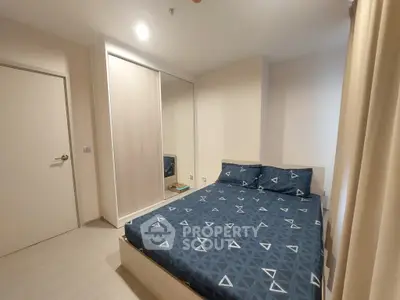 Modern bedroom with stylish bedding and mirrored wardrobe in a cozy apartment.