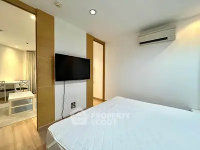 Modern bedroom with air conditioning and wall-mounted TV in a stylish apartment.