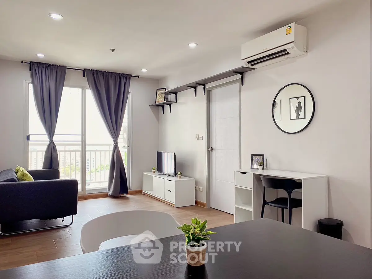 Modern living room with stylish decor, air conditioning, and natural light from large windows.