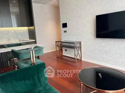 Luxurious modern living room with elegant green velvet chairs and sleek marble accents.