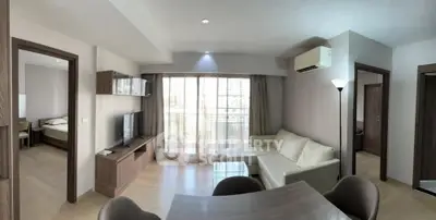 Spacious modern living room with natural light and elegant furnishings in a stylish apartment.