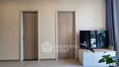 Modern living room with TV and two wooden doors, minimalist design
