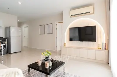 Modern living room with sleek design, featuring a wall-mounted TV, air conditioning, and stylish decor.