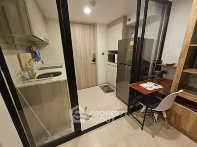 Modern compact kitchen with open layout and sleek appliances in a cozy apartment.