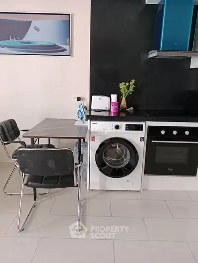 Modern kitchen with washing machine and dining area, sleek appliances, and stylish decor.