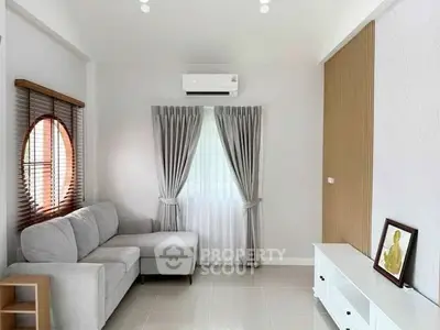 Modern living room with sleek design, featuring a cozy gray sofa and elegant curtains.