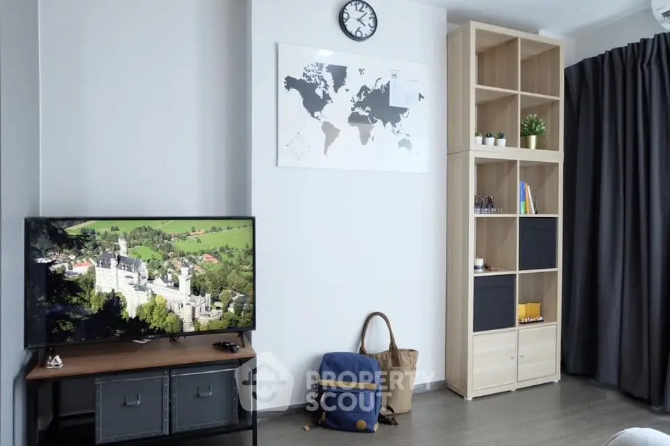 Modern living room with TV, world map decor, and stylish shelving unit.