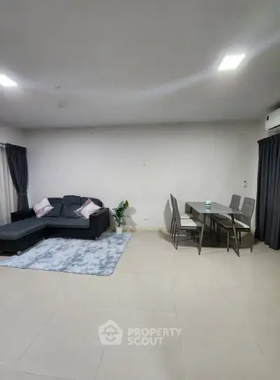 Spacious living room with modern furniture and elegant dining area, perfect for family gatherings.