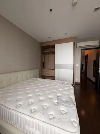 Spacious bedroom with modern design and built-in wardrobe, featuring a comfortable bed and air conditioning.