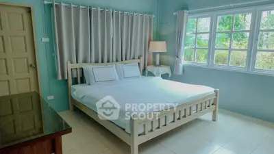 Bright and airy bedroom with large window and cozy decor, perfect for relaxation.