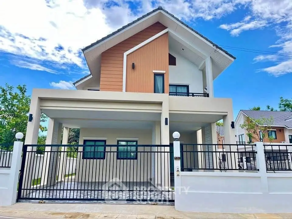 Modern two-story house with sleek design and spacious driveway under a clear blue sky.