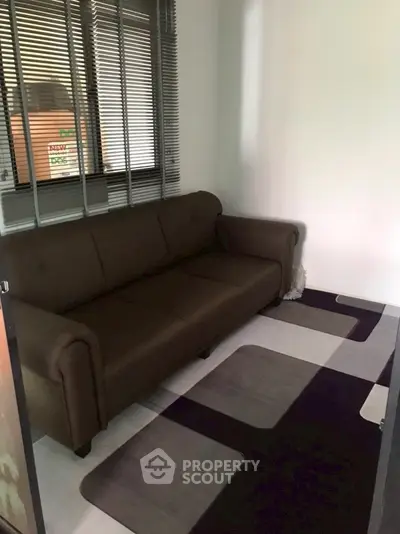 Cozy small living room with brown sofa and modern rug