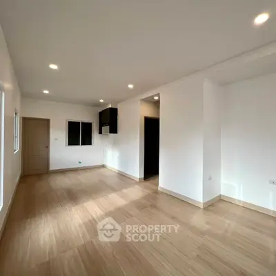 Spacious modern living room with wooden flooring and recessed lighting
