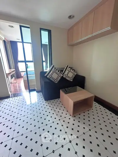 Chic living room with modern decor and stylish flooring, featuring a cozy sofa and elegant glass coffee table.