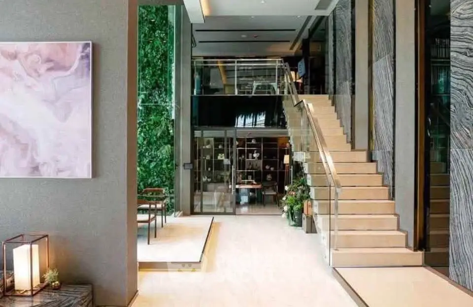 Luxurious modern building entrance with elegant staircase and lush greenery