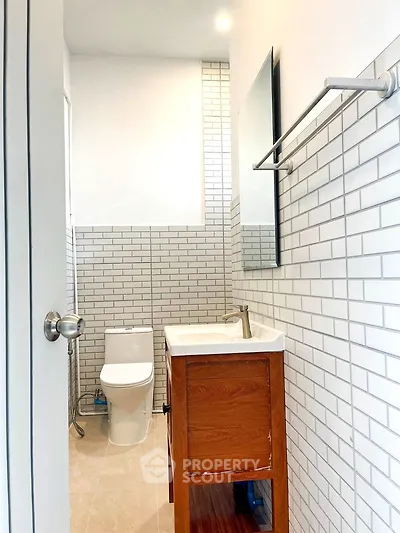 Modern bathroom with sleek white tiles and wooden vanity