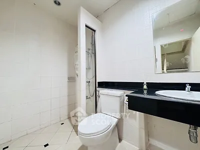 Modern bathroom with sleek black countertop and white tiles