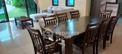 Spacious living room with elegant dining set and cozy sofa, perfect for family gatherings.