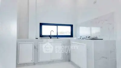 Sleek modern kitchen with minimalist design and large window for natural light.