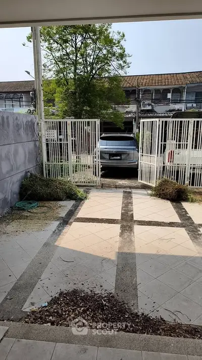 Charming townhouse entrance with gated parking and tiled pathway