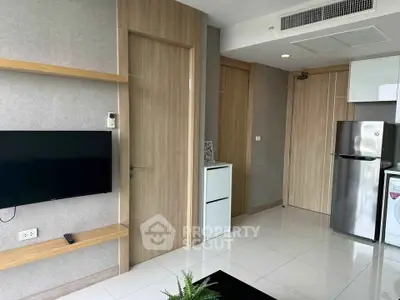 Modern apartment interior with sleek kitchen and wall-mounted TV