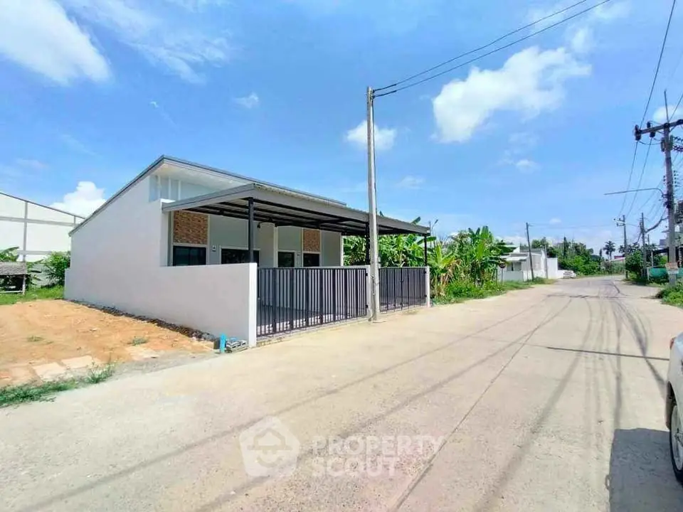 Modern single-story house with sleek design and spacious driveway in a serene neighborhood.