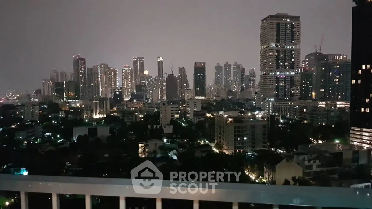 Stunning city skyline view from a high-rise balcony at night, showcasing urban living.