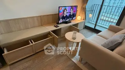 Modern living room with balcony, featuring stylish furniture and a flat-screen TV.