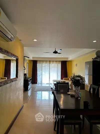 Spacious living room with dining area, modern decor, and large windows for natural light.