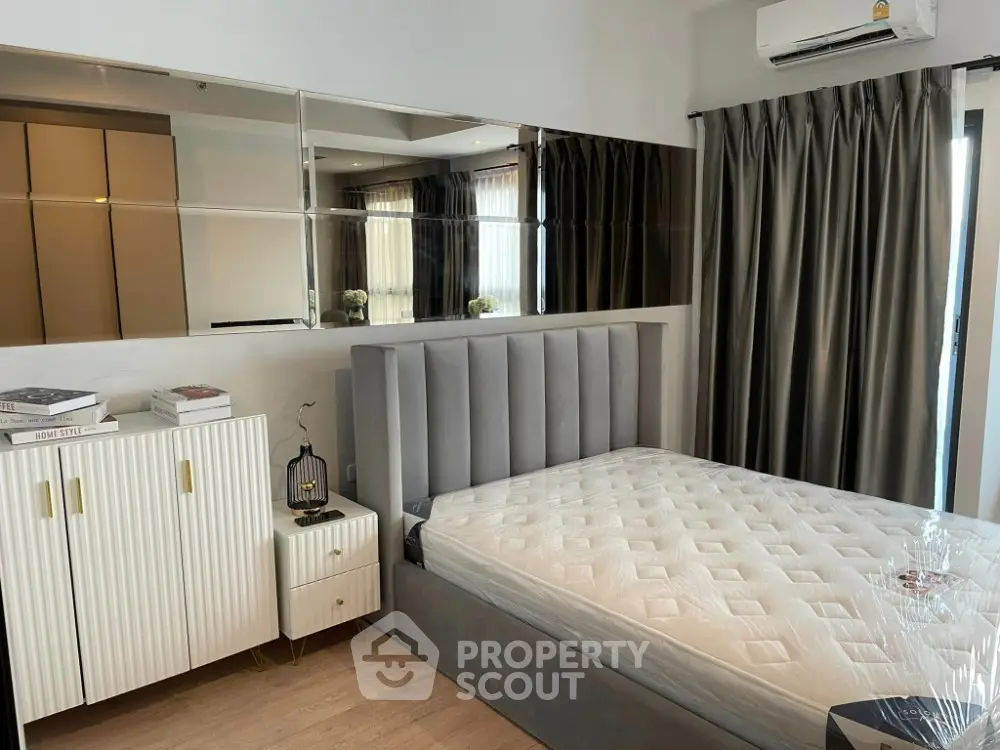 Modern bedroom with stylish decor and mirrored wall panels