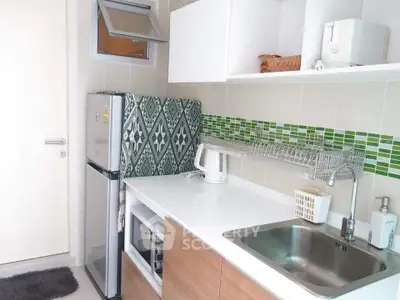 Modern kitchen with sleek white cabinets and green mosaic backsplash