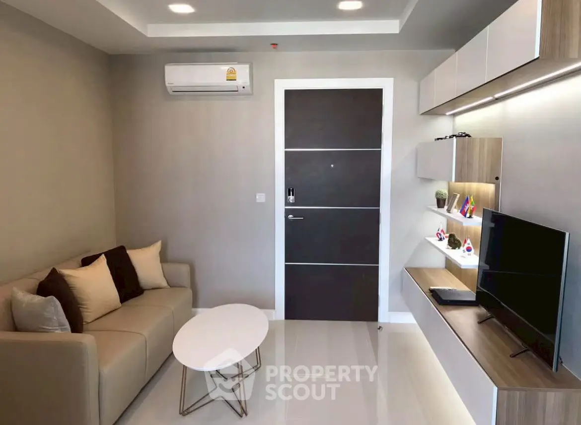 Modern living room with sleek furniture and wall-mounted TV, perfect for urban living.