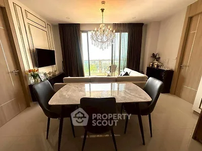 Elegant living room with chandelier and dining area, featuring a large window with a scenic view.