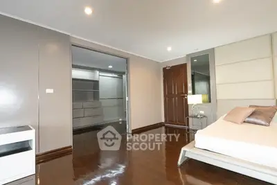 Spacious modern bedroom with sleek wooden flooring and elegant decor