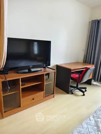 Cozy bedroom with TV stand and study desk, perfect for relaxation and productivity.