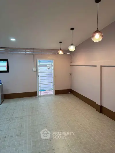Spacious interior with modern lighting and tiled flooring, ideal for versatile use.
