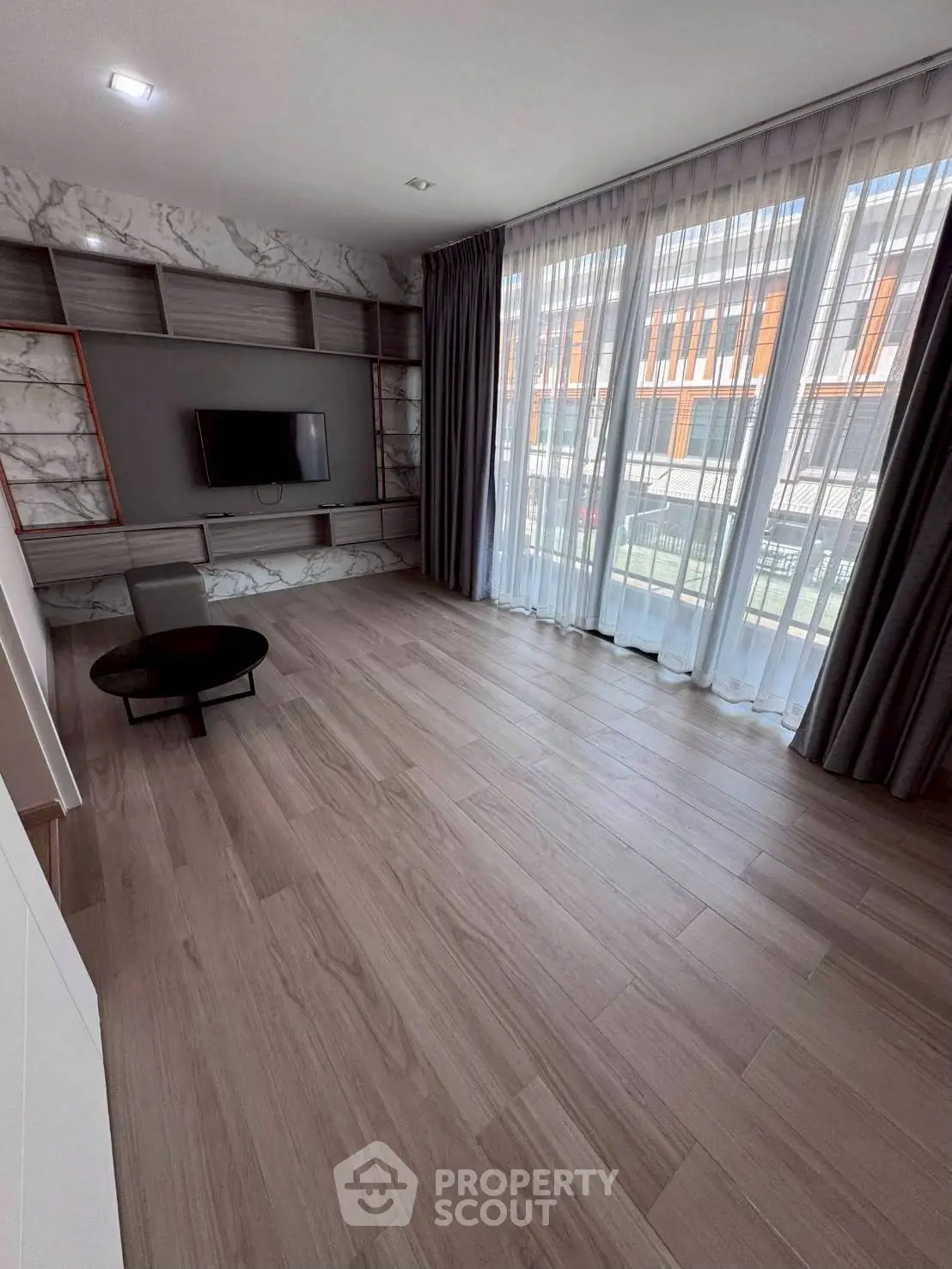 Spacious modern living room with large windows and elegant flooring