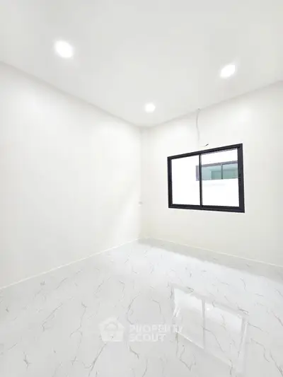 Bright empty room with modern white tile flooring and large window.