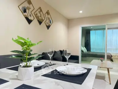 Modern open-plan living room with elegant dining setup and cozy bedroom view.