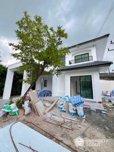 Modern two-story house under construction with spacious yard and contemporary design.