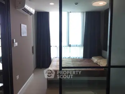 Modern bedroom with large windows and air conditioning in a stylish apartment.