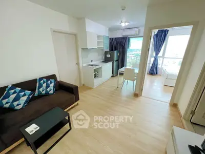 Modern open-layout apartment with kitchen, living area, and scenic view from bedroom.