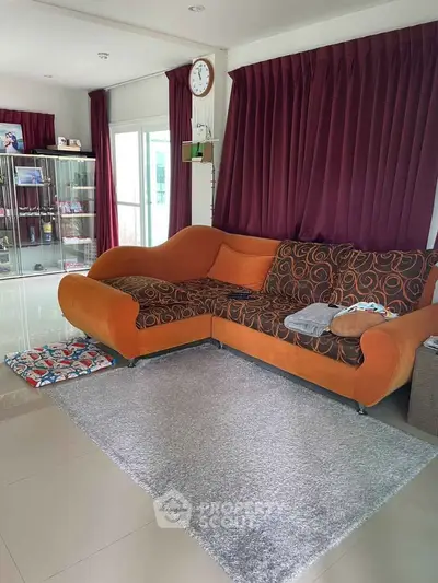 Spacious living room with stylish orange sofa and elegant decor